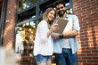 © NDABCREATIVITY - Cheerful happy couple using digital tablet outdoors