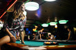 © NDABCREATIVITY - Young beautiful girl is playing billiards. Pleasant pastime, rest, entertainment.