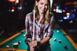 © NDABCREATIVITY - Young beautiful girl is playing billiards. Pleasant pastime, rest, entertainment.