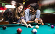 © NDABCREATIVITY - Couple drinking beer and playing snooker on date