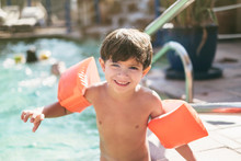 Little Three Years Old Kid Boy With Arms Float In Swimming Pool Ready To Go To Water