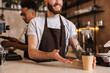 © Drobot Dean - Close up of a male barista giving the order at the cafe