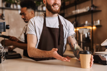 Wall Mural - Close up of a male barista giving the order at the cafe