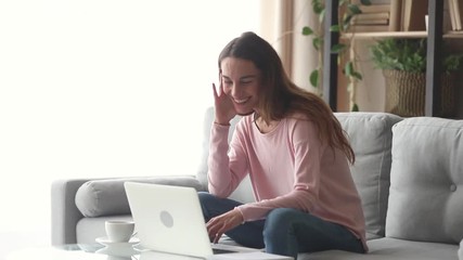 Wall Mural - Happy young woman laughing looking at laptop screen watching comedy