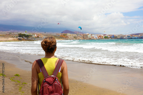 Back View Woman Enjoying Kite Surfers Show In El Medano