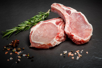 closeup two pieces of raw meat served with green rosemary