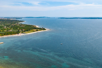 Aerial view of the seaside with buildings and greens trees over the ocean