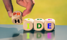 Coming Out Concept. Hand Turns A Cube And Changes The Word "hide" To "pride".