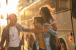 © BalanceFormCreative - Group of friends hangout at the city street.They embrace each other and laughing.One man carrying female friend on his back.