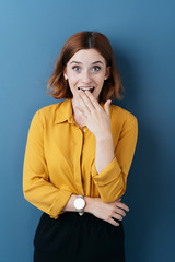 Wall Mural - Shocked excited young woman over blue