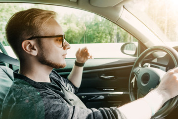 Wall Mural - European male driver businessman driving a car on a sunny trip.