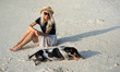 © Artem Markin - A girl in a straw hat sits on the morning beach. Modern girl on vacation