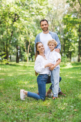 Wall Mural - happy family looking at camera and posing in park