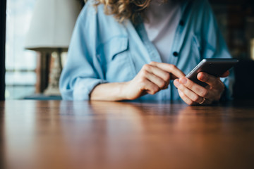 Unrecognizable young woman using mobile phone