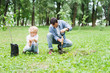 © LIGHTFIELD STUDIOS - father digging with shovel near son for planting seedling in park