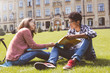 © Oleksandr - Smiling students African American male in glasses with books and a girl near college.