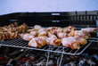 © Baifoworld - Grill bacon roll in a BBQ with coal. Marinated meat in metal net during garden party. Summer barbecue outdoors. Hot embers to cook