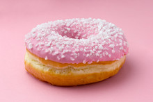 Pink Frosted Donut Sprinkled With Crystal Sugar Isolated On Pink Background.