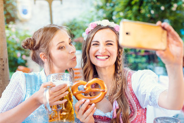 Best friends in Bavarian Tracht making a Selfie with the phone