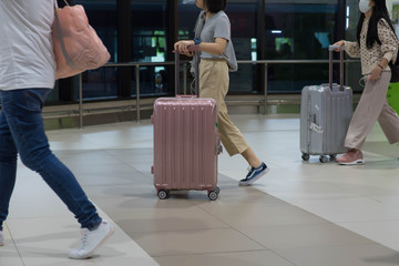 Traveler pulling suitcase in airport terminal.