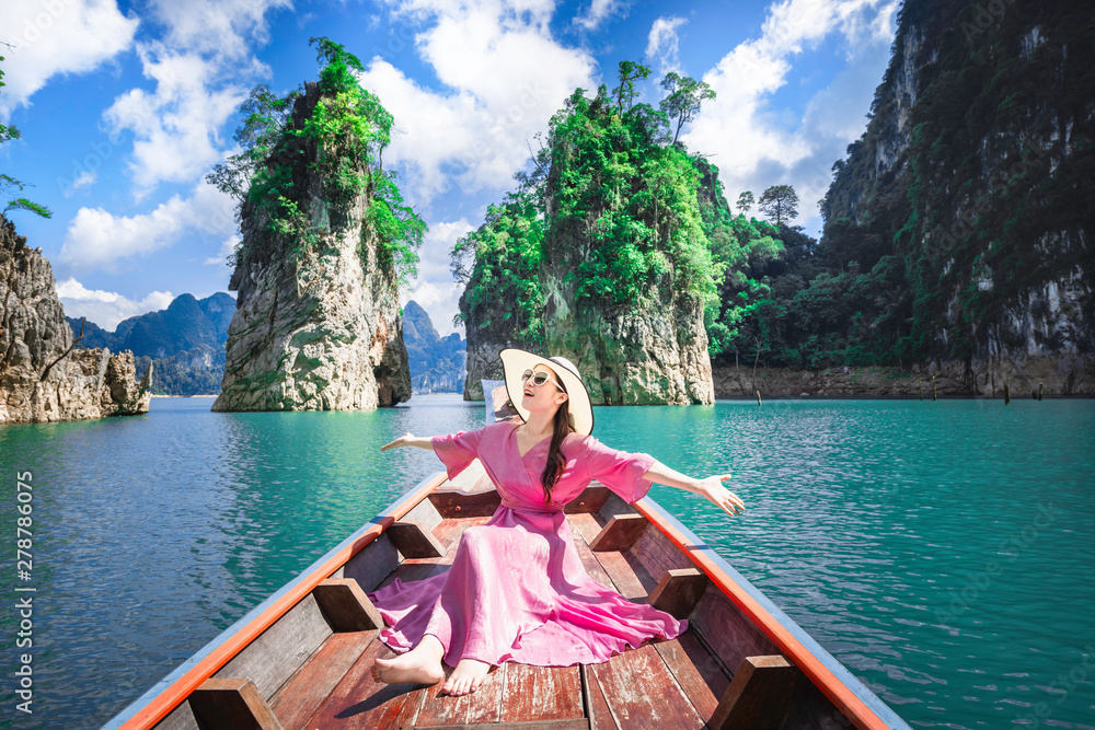 asian woman post for take shot on boat  in Ratchaprapha dam Khao sok national park at suratthani,Thailand. - obrazy, fototapety, plakaty 