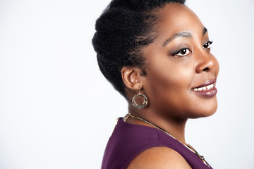 corporate African American business woman with an Afro is wearing jewelry and business attire for professional head shots. shot on white and grey isolated backdrop