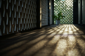 Selective focus on cement floor of corridor reflects the light of sunset with blurred bokeh lights background.