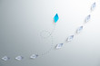 © Worawut - Group of white paper ship in one direction and one blue paper ship pointing in different way on white background. Business for innovative solution concept, copy space