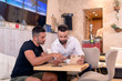 © Jovan - Two friends looking at menu in restaurant.