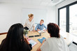 © DragonImages - Group of business people sitting at the table and discussing working process in team during business meeting at board room