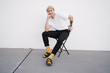 © TONL - Portrait of smiling young man sitting on chair