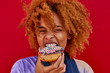 © Westend61 - Portrait of woman eating a donut