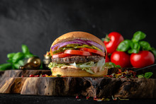 Tasty Grilled Burger With Beef, Cheese, Vegetables Delicious Grilled Hamburger On A Dark Background. Free Space For Text