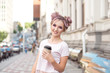 © Viktoria - Smiling beautiful girl with pink hair hairstyle walks down the street with a cup of coffee enjoying a beautiful sunny day