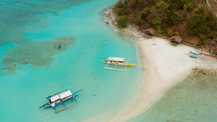 aerial seascape tropical island and sand beach, turquoise water and coral reef. malacory island, Philippines, Palawan. tourist boats on coast tropical island.