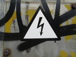 High voltage warning sign on an old rusty metal door.