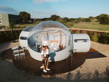 Aerial View Of A Young Couple Kissing By Unusual Bubble Hotel