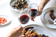 © Pablo Garcia/ADDICTIVE STOCK - From above crop hands of people clinking with wine glasses while eating delicious meal on white background