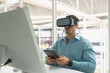 © wavebreak3 - Male executive holding digital tablet while using virtual reality headset at desk