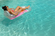 © wavebreak3 - Woman in bikini relaxing on a inflatable tube in swimming pool at the backyard of home