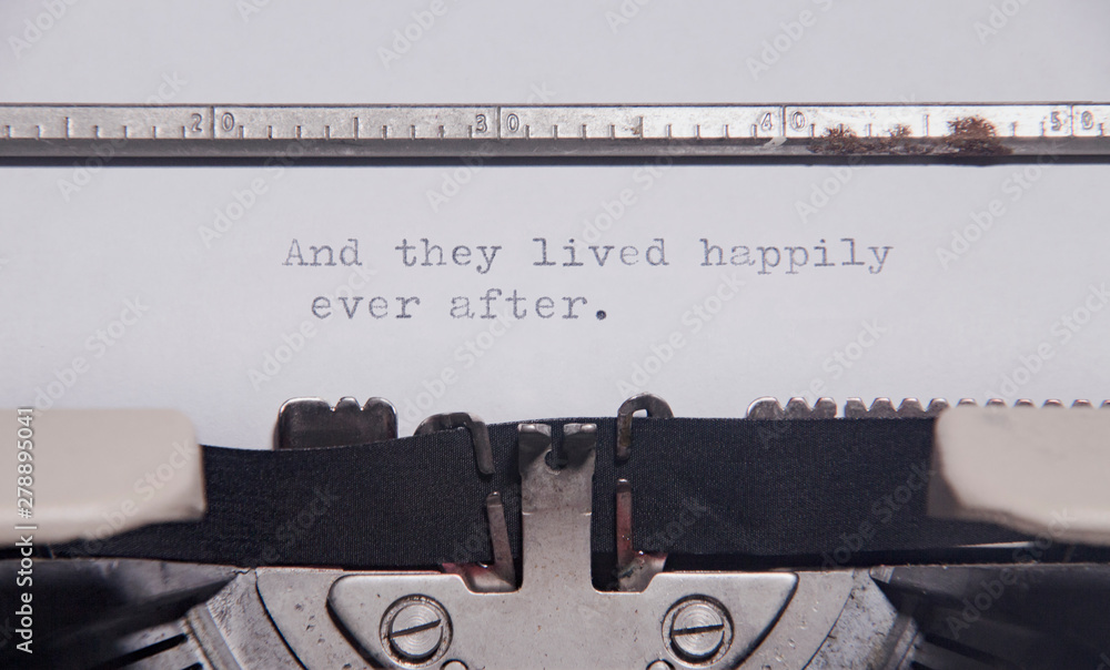 The ending phrase And they lived happily ever after, printed on a paper page inside an old vintage typewriter. Macro close-up shot. - obrazy, fototapety, plakaty 