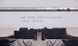 The ending phrase And they lived happily ever after, printed on a paper page inside an old vintage typewriter. Macro close-up shot.