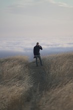 Vertical Shot Of A Male Looking At The Camera On Top Of The Mountain. Tam In Marin, CA