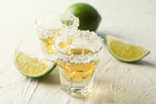 Tequila Shots With Salt And Lime Slices On White Background