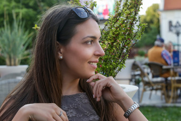 Wall Mural - Outdoor portrait of a young smiling woman sitting on the park bench