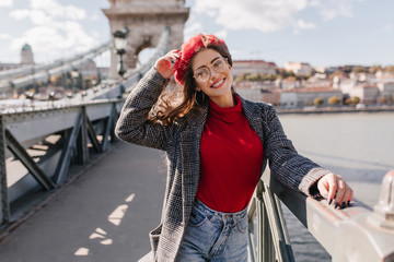 Wall Mural - amazing french woman posing with hair waving, relaxing during walk down the bridge. outdoor portrait