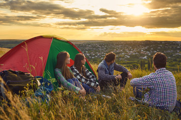 Wall Mural - Camping tent camp people tourists sitting the sunset in nature.