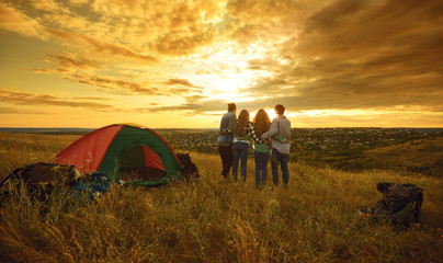 Wall Mural - Camping tent camp people tourists sitting the sunset in nature.