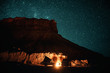 Lagerfeuer umstellt von einem Geländewagen und Campervan in der Nacht bei erg chebbi bei merzouga in Marokko unter einem Sternenhimmel 