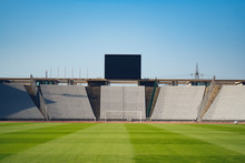 Sports Stadium And Blue Sky. Scoreboard, White Seats, Field.